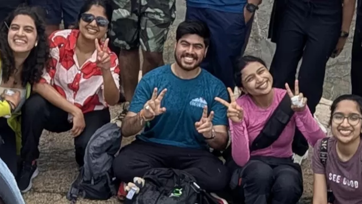 PDL fellows on a hike, smiling and holding up peace signs.